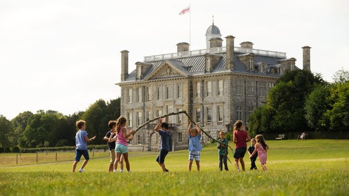 A groups of children playing with a huge tree branch